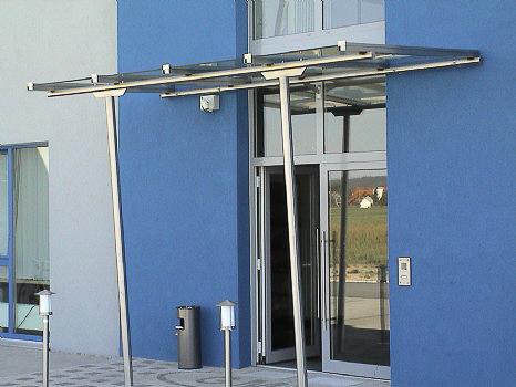 Liniengelagertes Glasvordach mit Stützen aus Edelstahl Rundrohr d=60 mm.