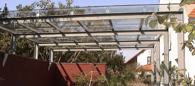 Glaskonstruktion bestehend aus Edelstahl-Glasträger (Doppelsteg aus Profil 30x20mm) abgehängt über Zugstäbe mit Spannschloß. Glasauflage aus VSG 10mm über Klemmprofil auf Edelstahl-Glasträger befestigt Abmessung: ca. 4500x1100 mm; inkl. Montage.